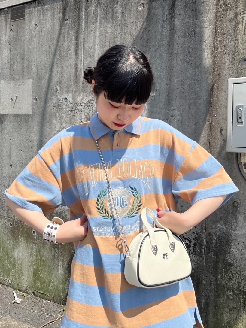 ブラック系のブーツ、ブルー系のその他パンツ、ホワイト系のボストンバッグを着用したレディースの春コーディネートの4枚目の写真