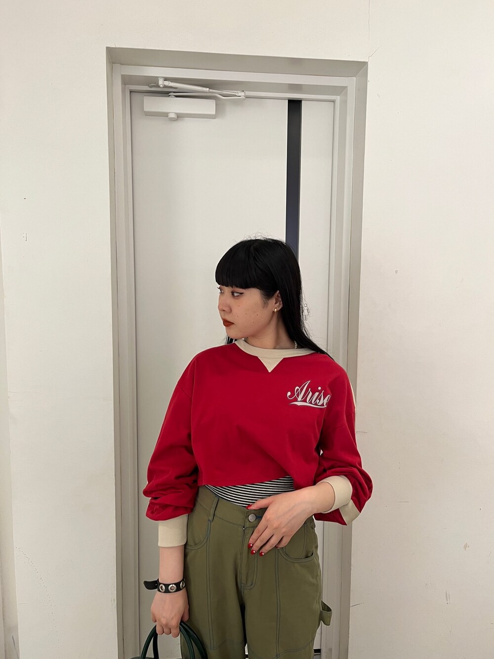 ブラック系のその他パンツ、レッド系のTシャツ/カットソーを着用したレディースの秋コーディネートの7枚目の写真