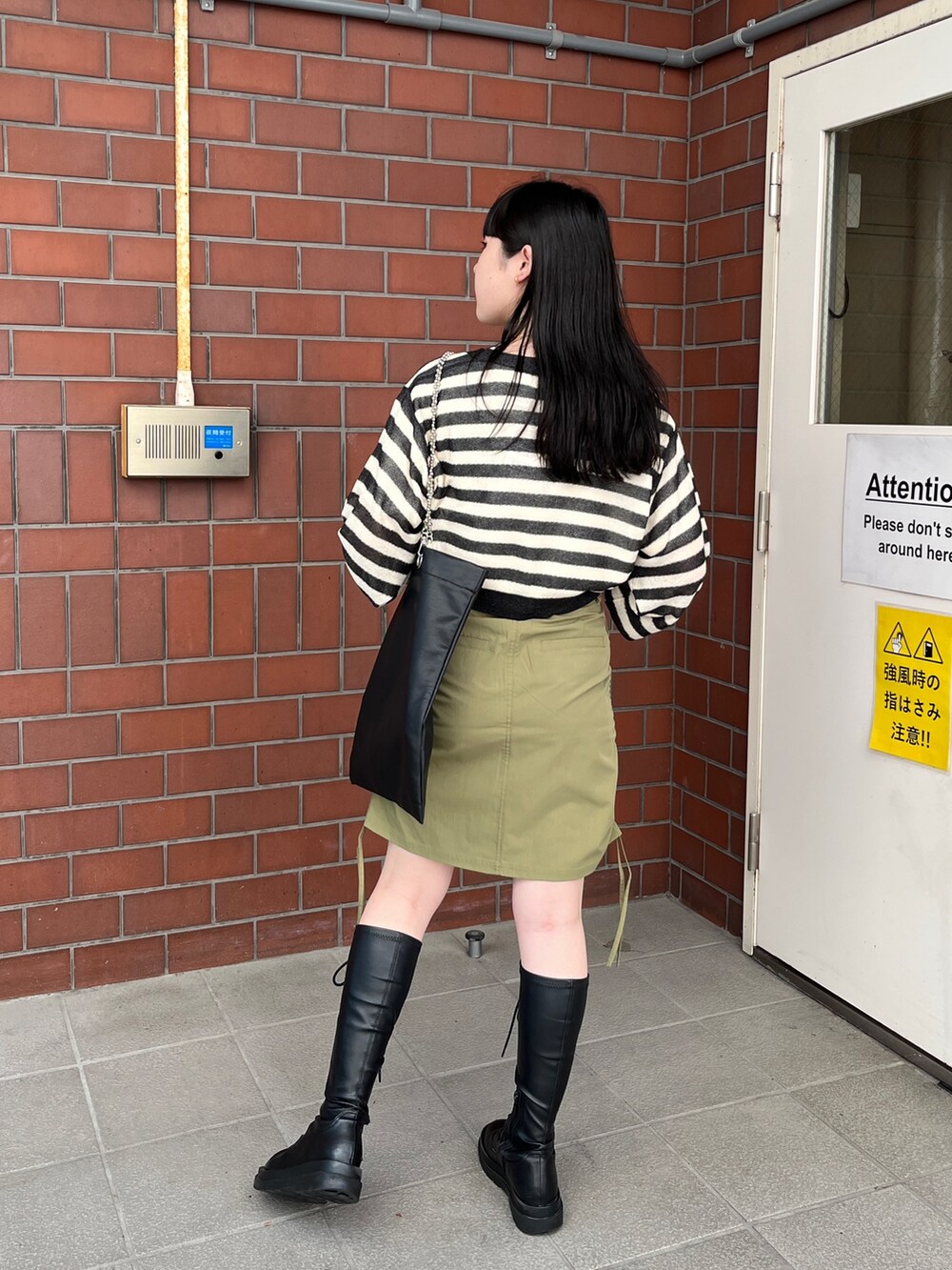 グリーン系のスカート、ブラック系のカーディガン/ボレロ、ホワイト系のTシャツ/カットソーを着用したレディースの夏コーディネートの3枚目の写真