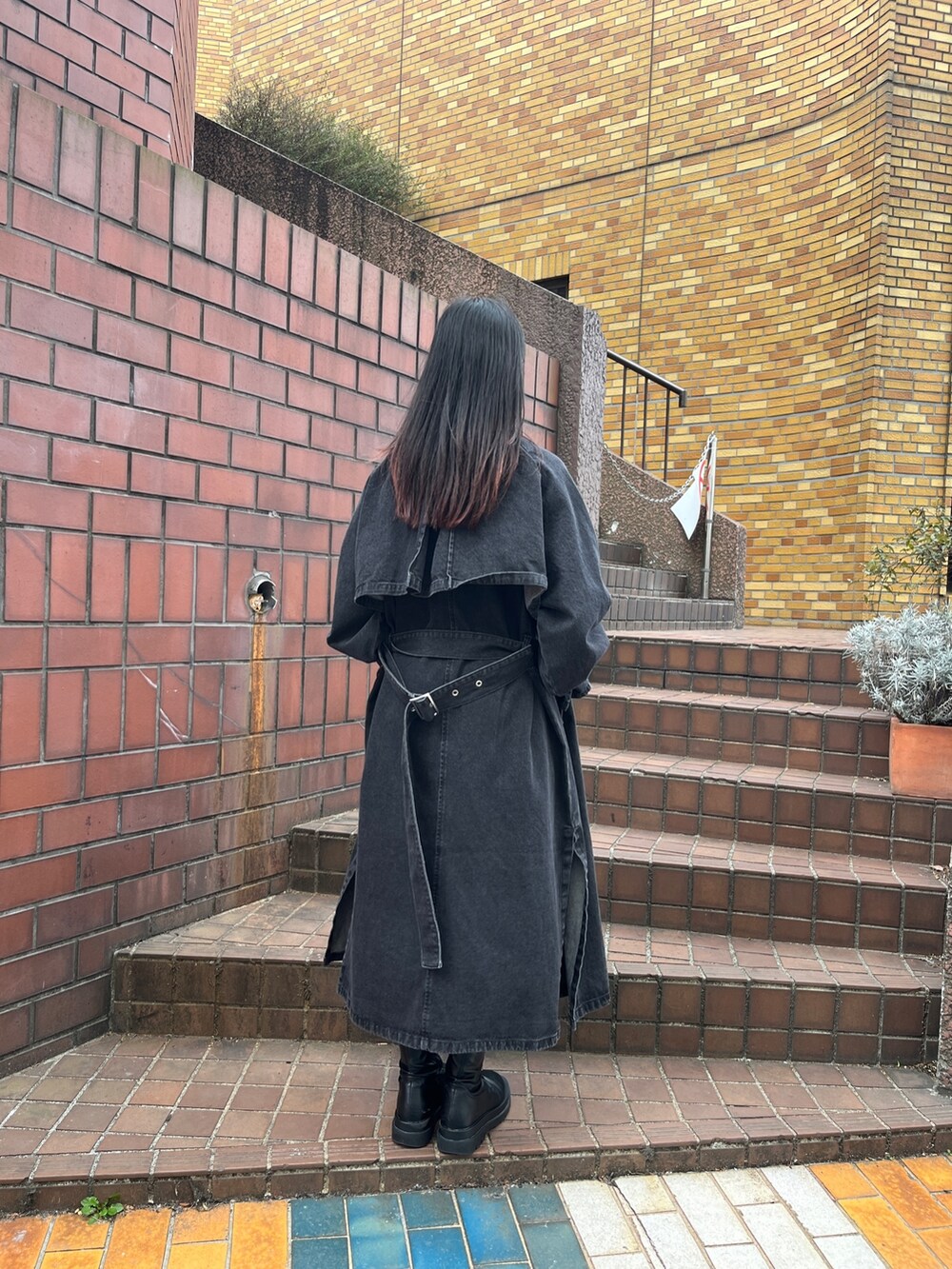 ブラック系のトレンチコート、ブラウン系のその他パンツ、ホワイト系のTシャツ/カットソーを着用したレディースの冬コーディネートの3枚目の写真