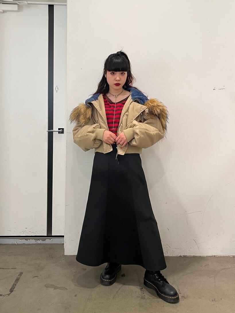 レッド系のTシャツ/カットソー、ベージュ系のその他アウター、ブラック系のスカートを着用したレディースの秋コーディネートの2枚目の写真