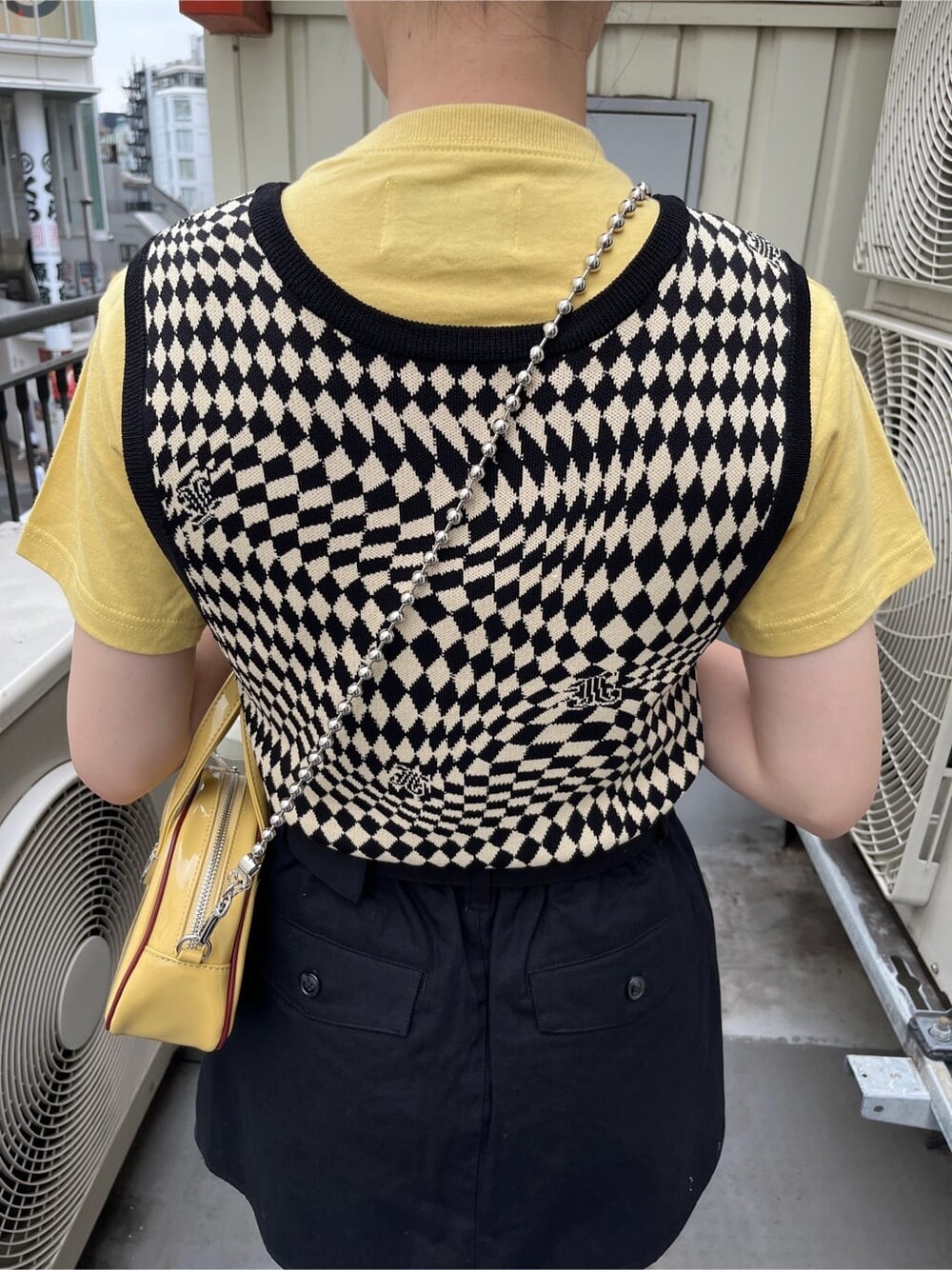 ブラック系のブーツ、ブラック系のニット/セーター、イエロー系のTシャツ/カットソーを着用したレディースの夏コーディネートの8枚目の写真