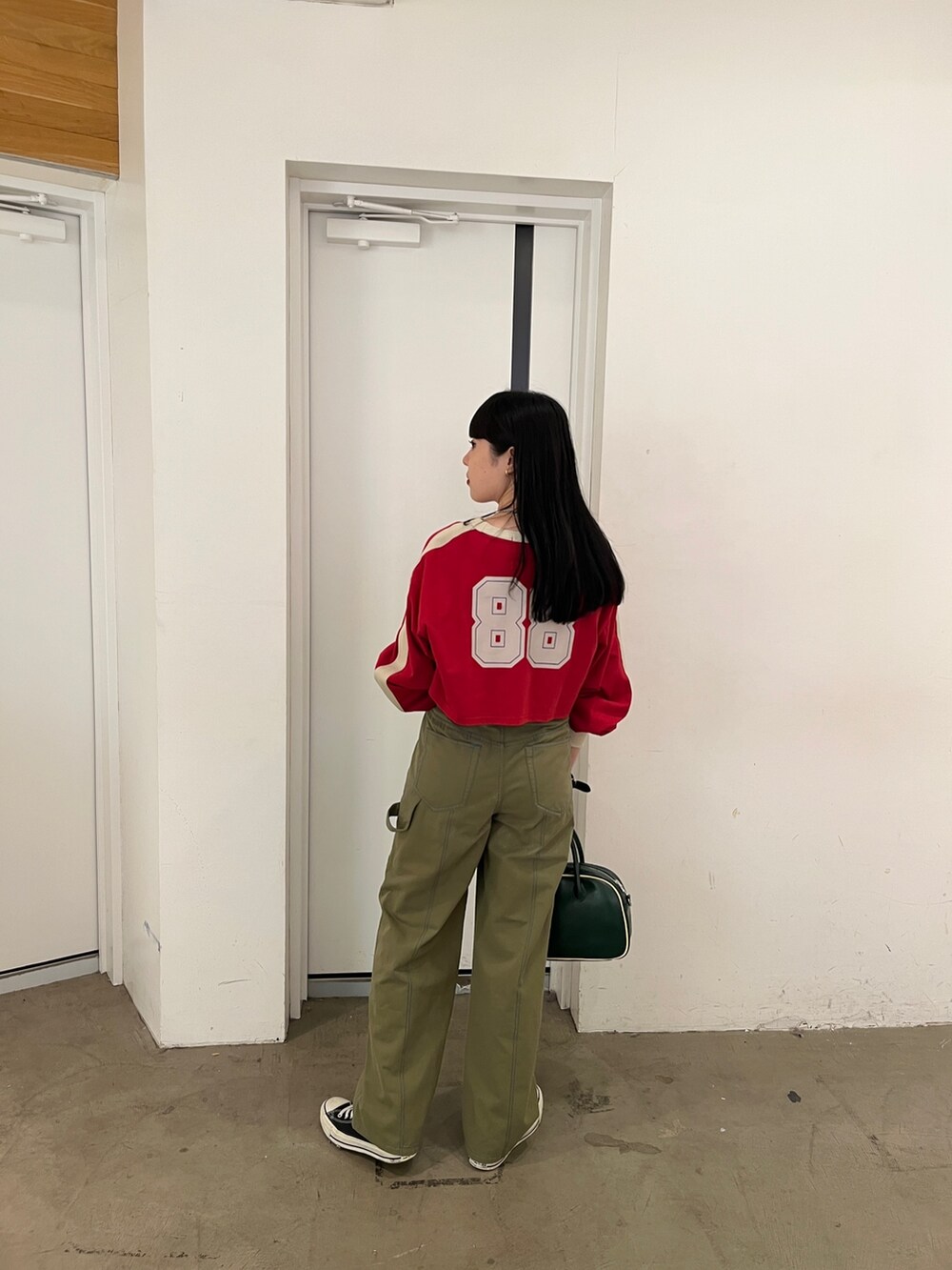 ブラック系のその他パンツ、レッド系のTシャツ/カットソーを着用したレディースの秋コーディネートの4枚目の写真