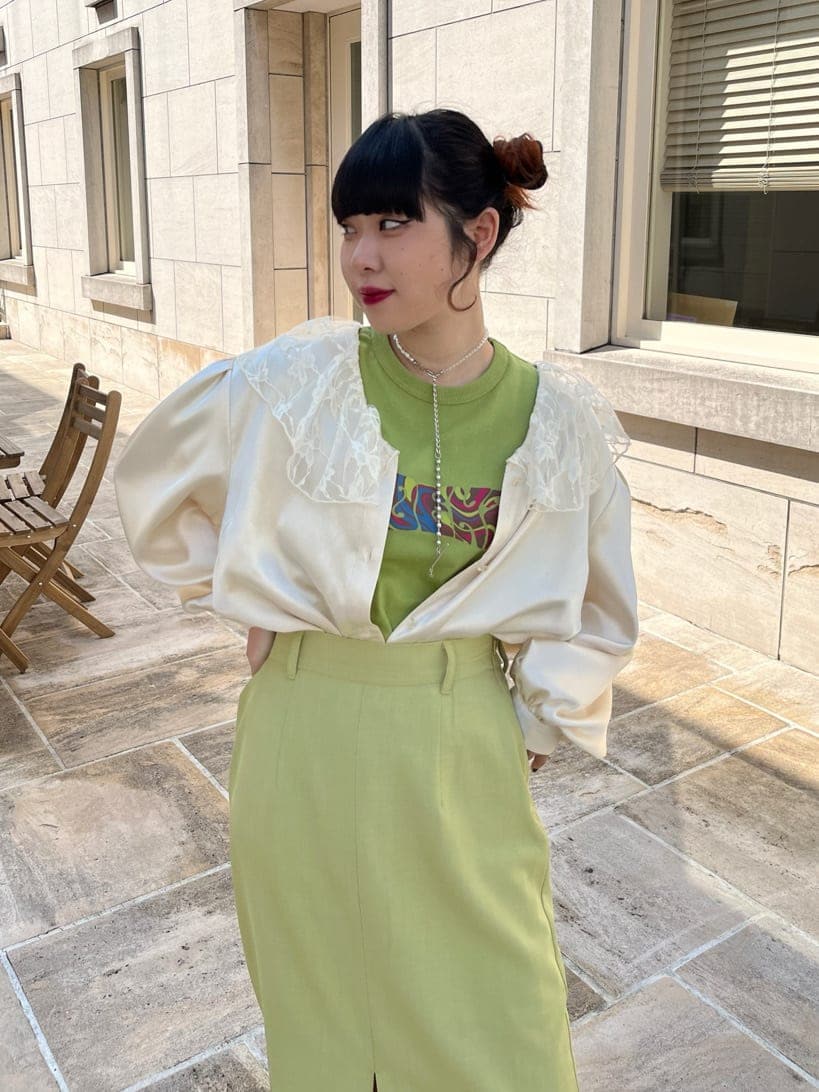 レッド系のブーツ、ホワイト系のシャツ/ブラウス、グリーン系のスカートを着用したレディースの春コーディネートの3枚目の写真