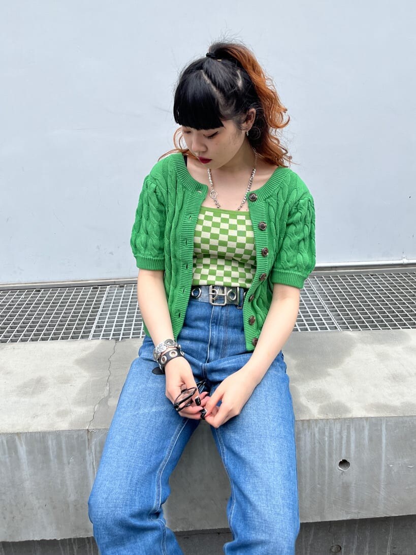 グリーン系のキャミソール、グリーン系のニット/セーター、ブラック系のサングラスを着用したレディースの春コーディネートの4枚目の写真