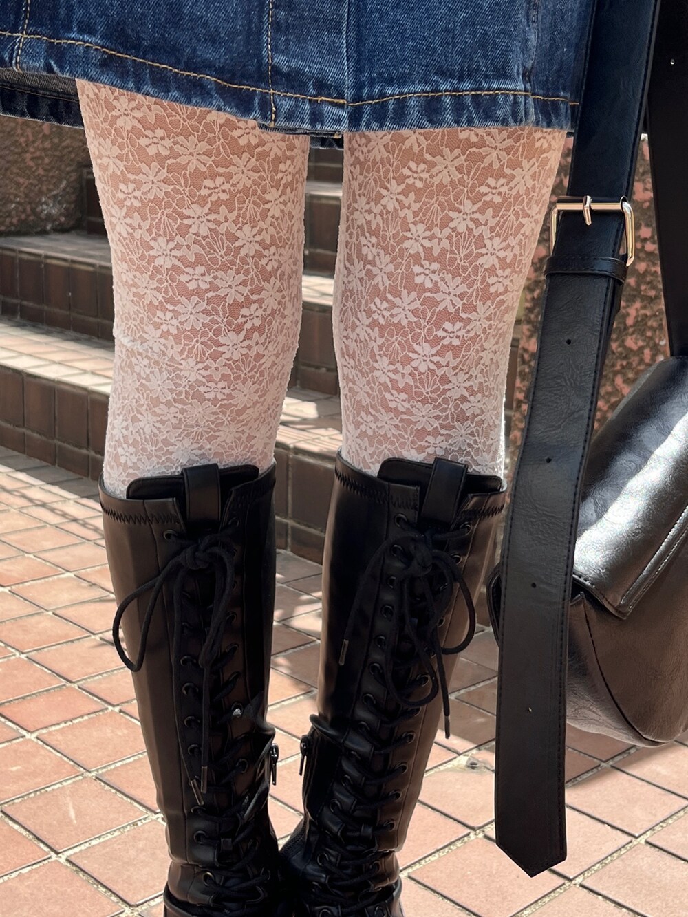 ホワイト系のショルダーバッグ、ブラック系のブーツ、ブルー系のワンピースを着用したレディースの春コーディネートの8枚目の写真