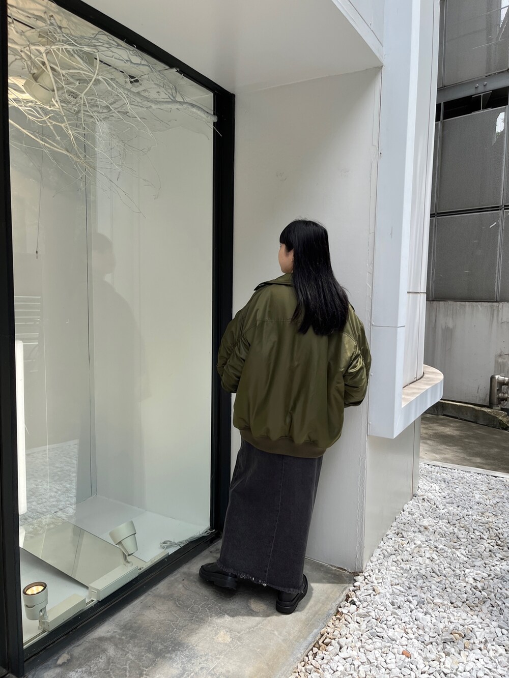 ベージュ系のMA-1、ブルー系のシャツ/ブラウス、ブラック系のデニムパンツを着用したレディースの夏コーディネートの4枚目の写真