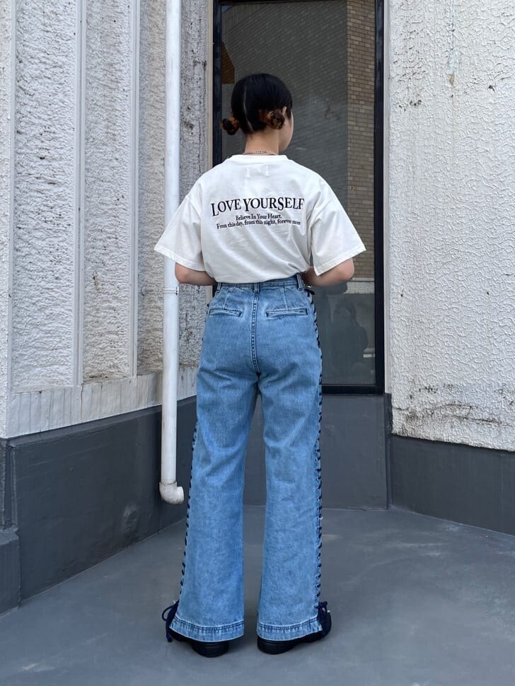 ブラック系のブーツ、ホワイト系のTシャツ/カットソー、ブルー系のデニムパンツを着用したレディースの春コーディネートの2枚目の写真