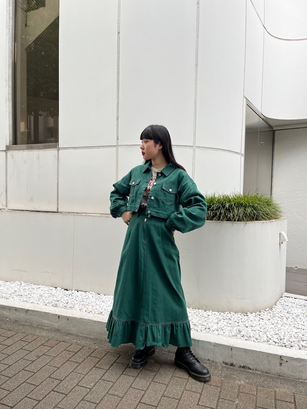 ホワイト系のTシャツ/カットソー、ブラック系のブーツ、グリーン系のワンピースを着用したレディースの夏コーディネートの2枚目の写真