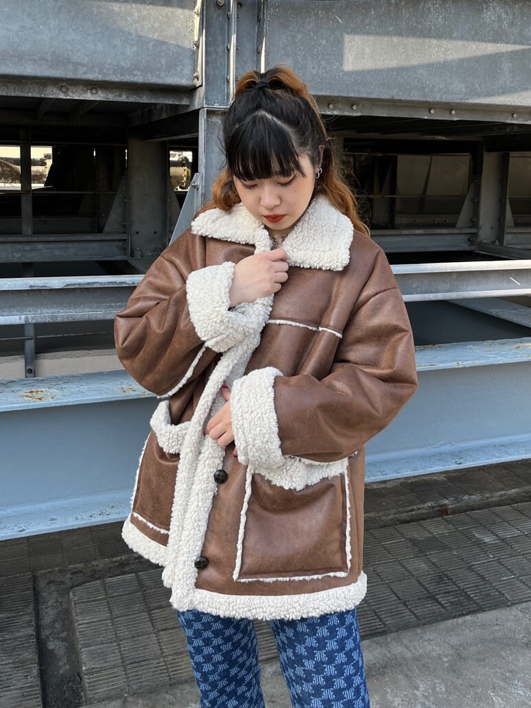 ブルー系のムートンコート、ブルー系のデニムパンツを着用したレディースの冬コーディネートの2枚目の写真