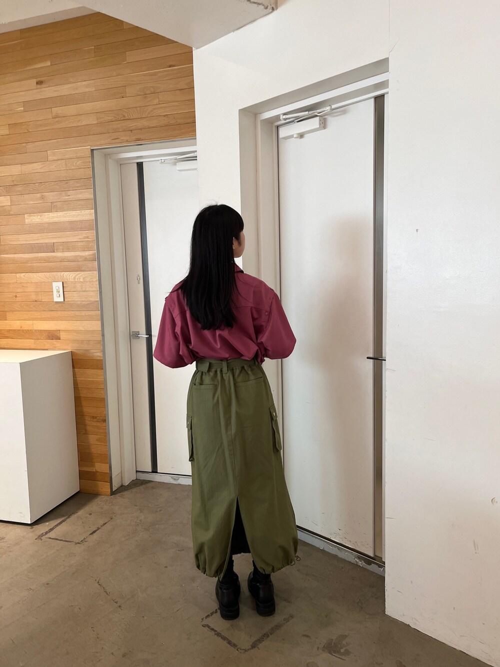 グリーン系のスカート、ピンク系のシャツ/ブラウス、ブラック系のブーツを着用したレディースの春コーディネートの3枚目の写真