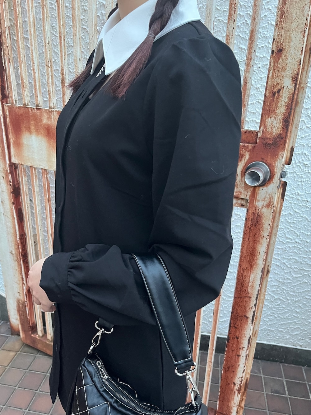 ブラック系のワンピース、ブラック系のブーツを着用したレディースの冬コーディネートの8枚目の写真