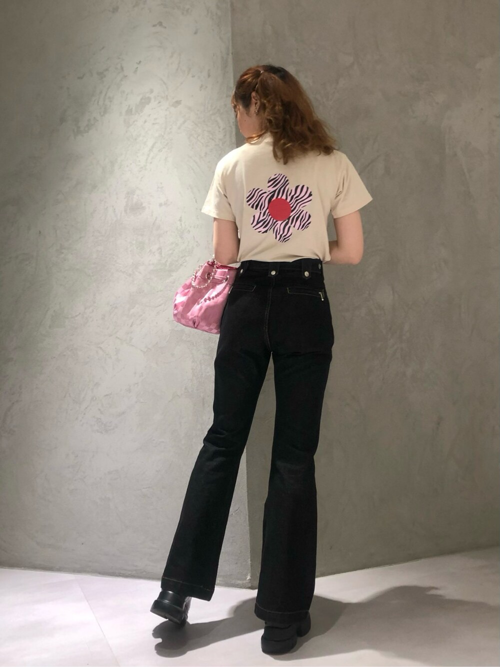 ピンク系のショルダーバッグ、ブラック系のデニムパンツ、ホワイト系のTシャツ/カットソーを着用したレディースの春コーディネートの3枚目の写真