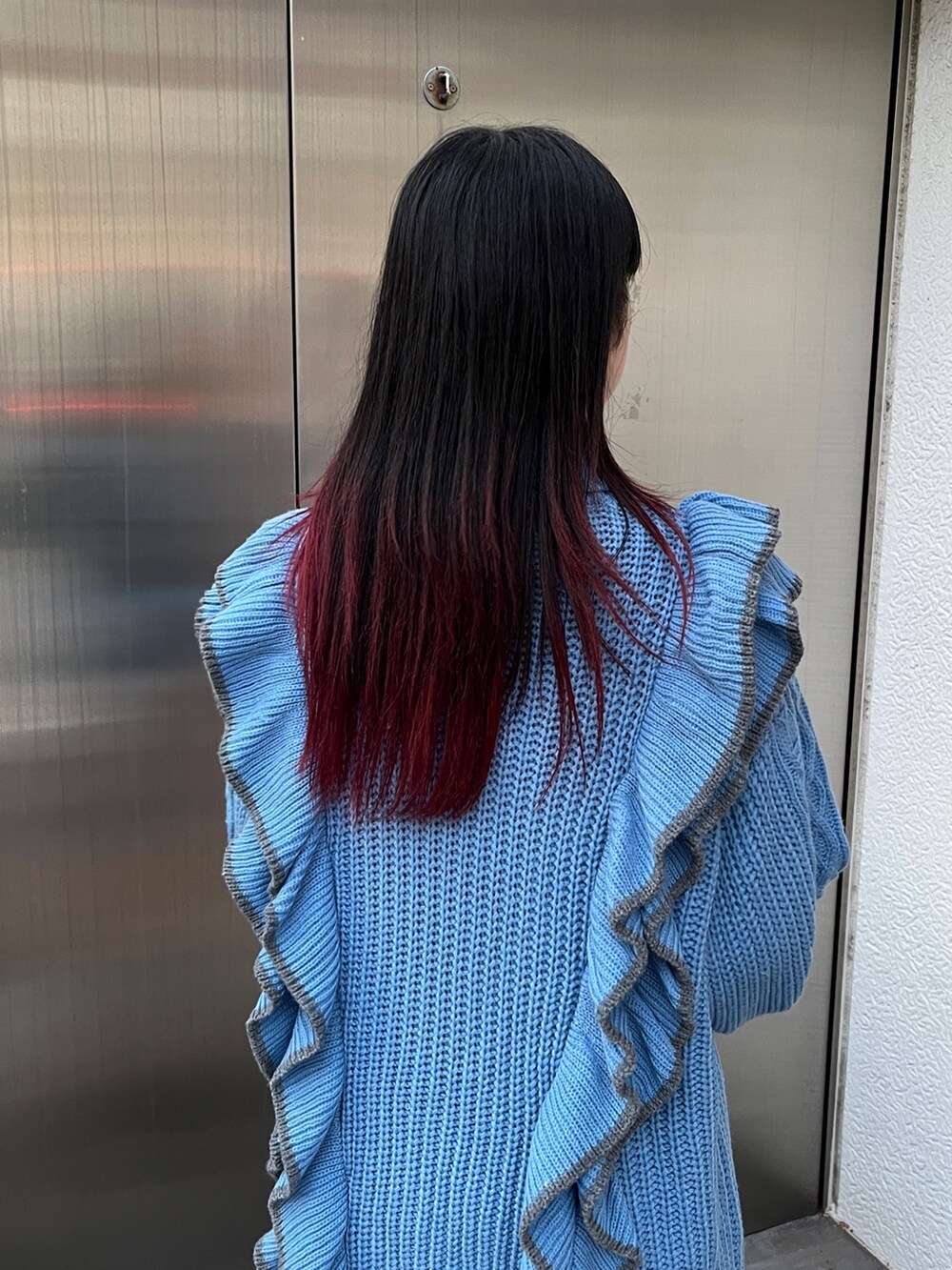 ブルー系のニット/セーター、ブラック系のブーツを着用したレディースの冬コーディネートの10枚目の写真