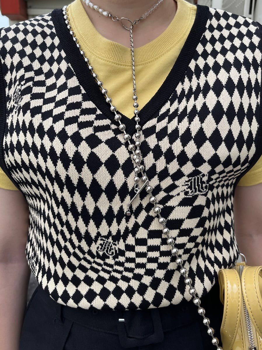 ブラック系のブーツ、ブラック系のニット/セーター、イエロー系のTシャツ/カットソーを着用したレディースの夏コーディネートの6枚目の写真