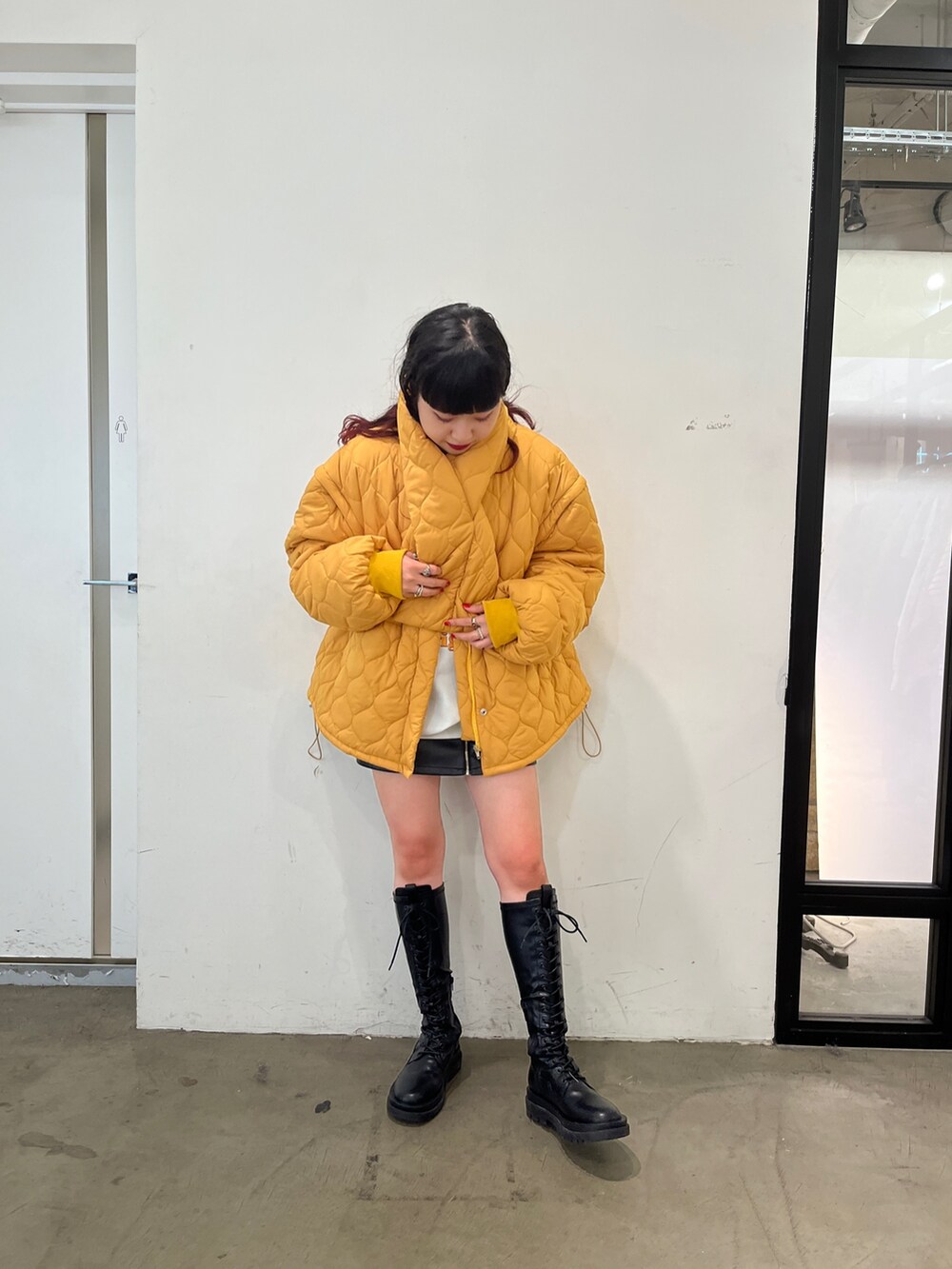 ブラック系のブーツ、グレー系のスウェット、イエロー系のその他アウターを着用したレディースの秋コーディネートの2枚目の写真