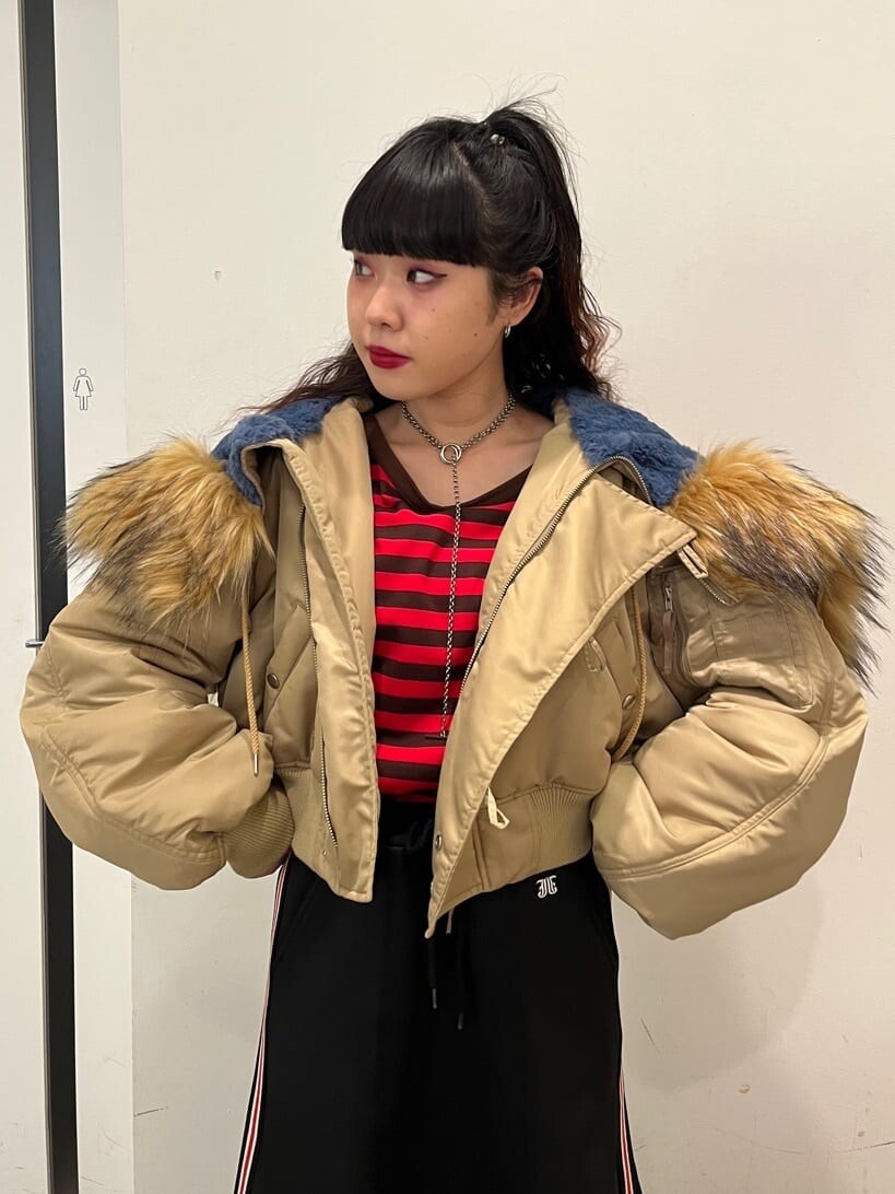 レッド系のTシャツ/カットソー、ベージュ系のその他アウター、ブラック系のスカートを着用したレディースの秋コーディネートの4枚目の写真