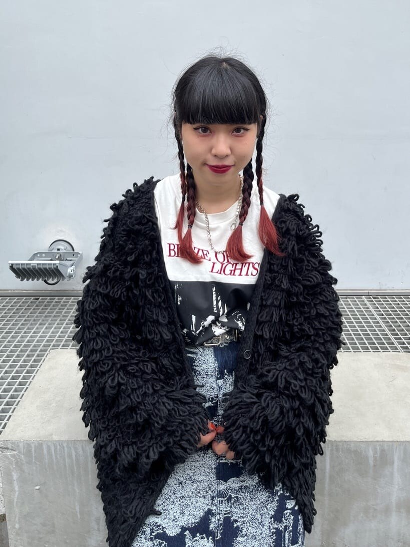 ブルー系のデニムスカート、ホワイト系のTシャツ/カットソー、ブラック系のカーディガン/ボレロを着用したレディースの秋コーディネートの4枚目の写真