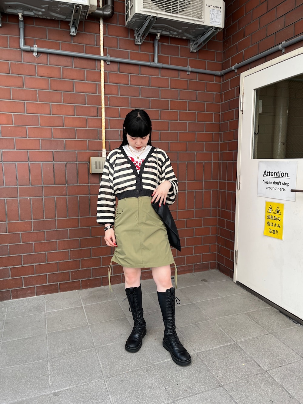 グリーン系のスカート、ブラック系のカーディガン/ボレロ、ホワイト系のTシャツ/カットソーを着用したレディースの夏コーディネートの2枚目の写真