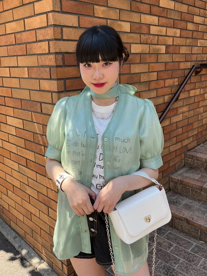 ブラック系のブーツ、ブラック系のデニムパンツ、グリーン系のシャツ/ブラウスを着用したレディースの春コーディネートの5枚目の写真