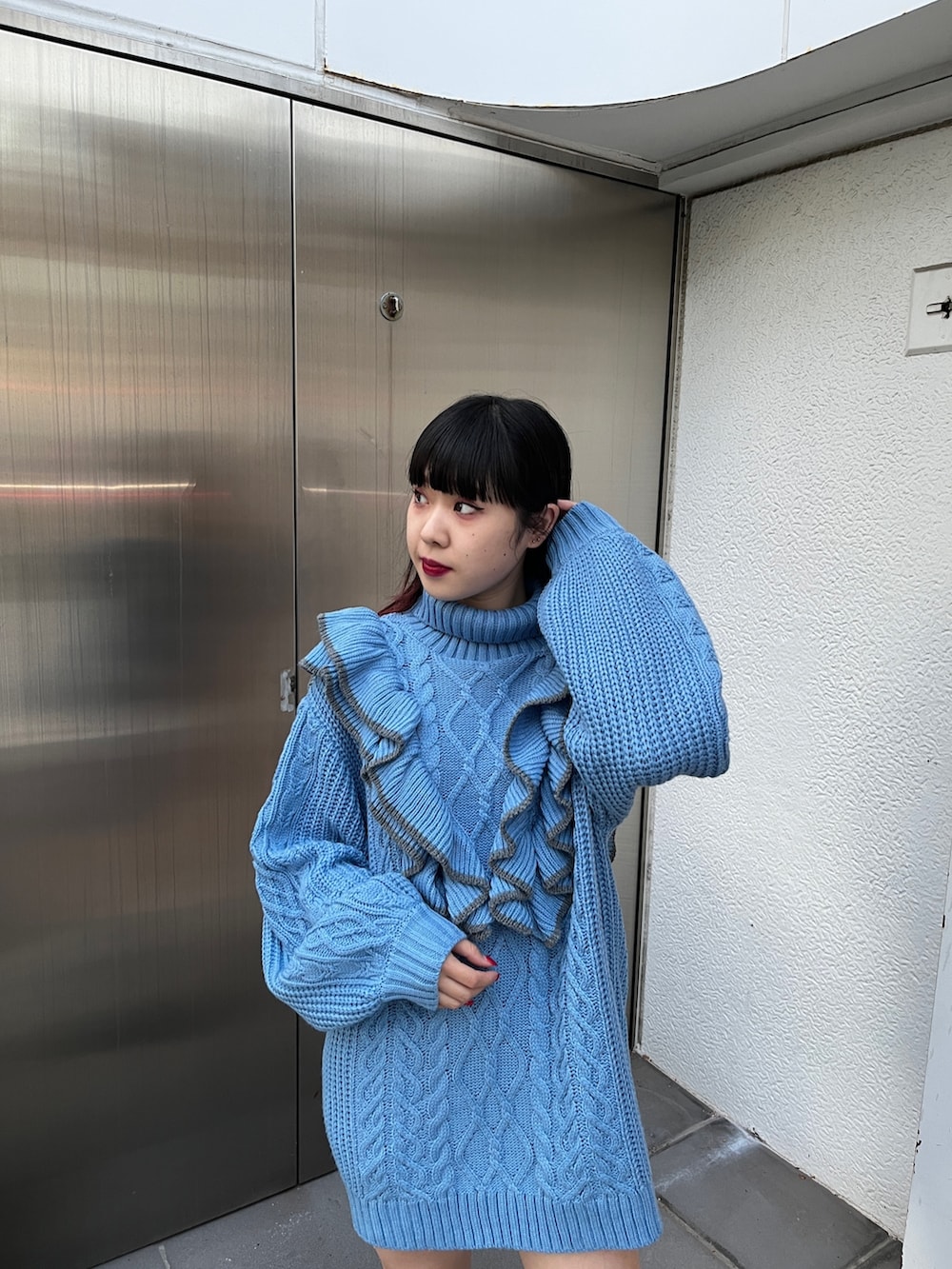 ブルー系のニット/セーター、ブラック系のブーツを着用したレディースの冬コーディネートの7枚目の写真