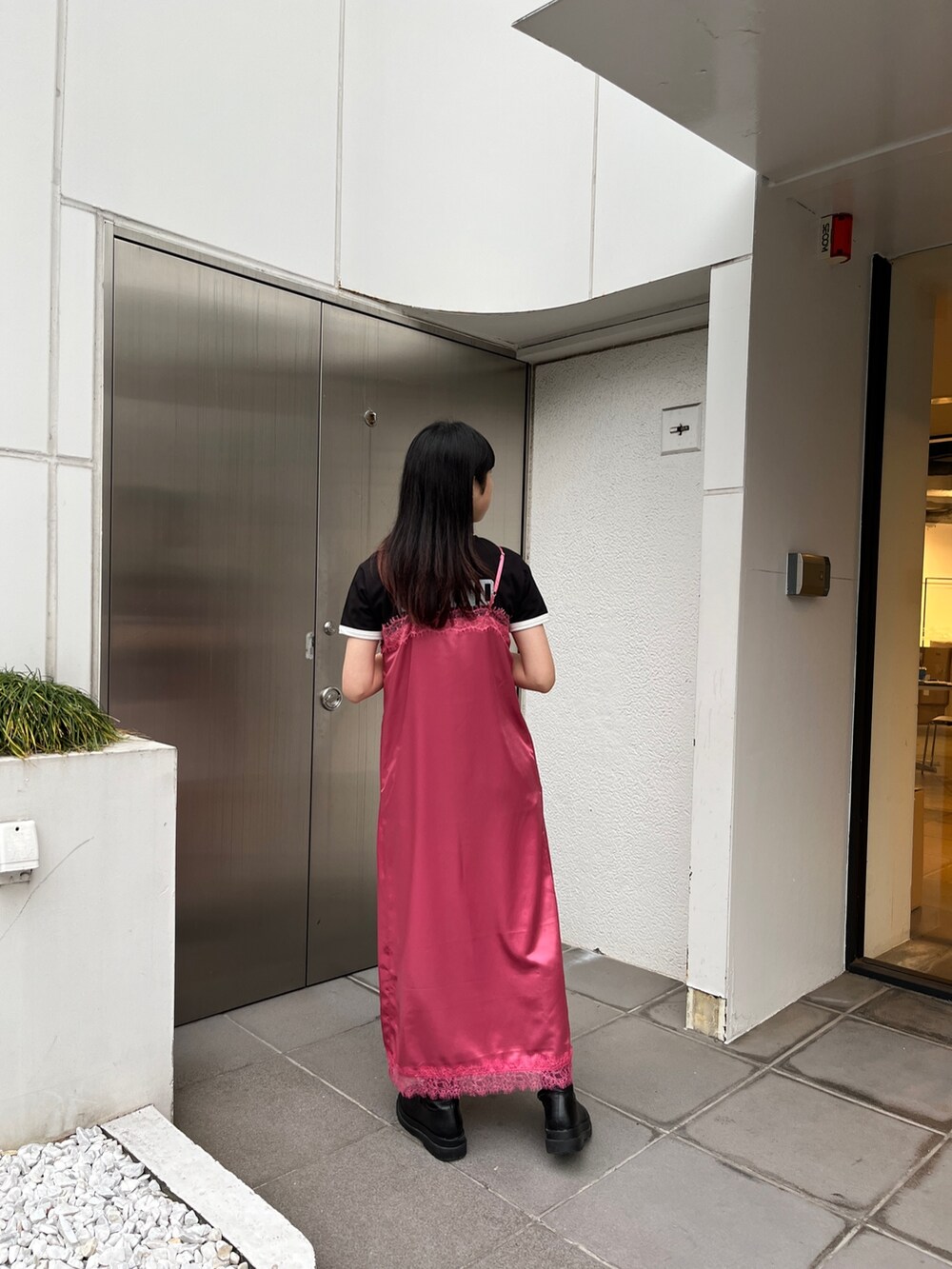 ピンク系のワンピース、ブラック系のブーツ、ブラック系のTシャツ/カットソーを着用したレディースの冬コーディネートの3枚目の写真