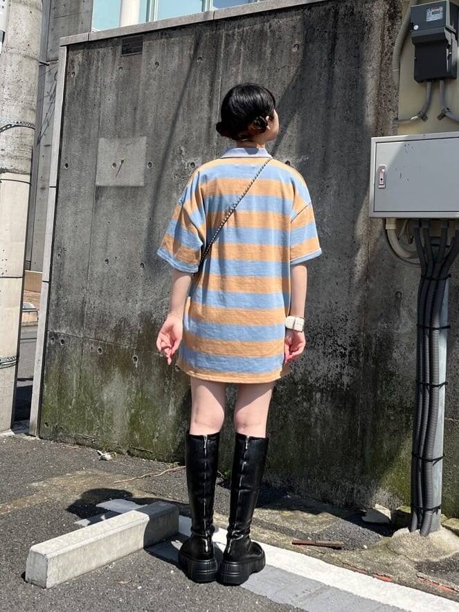 ブラック系のブーツ、ブルー系のその他パンツ、ホワイト系のボストンバッグを着用したレディースの春コーディネートの3枚目の写真