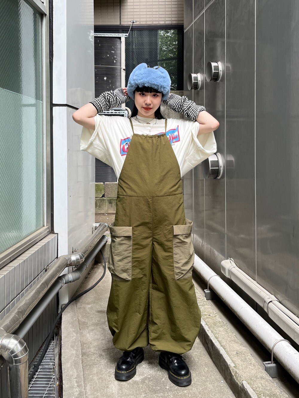 ホワイト系のTシャツ/カットソー、ブラック系のブーツ、ブラック系のアームカバーを着用したレディースの夏コーディネートの2枚目の写真