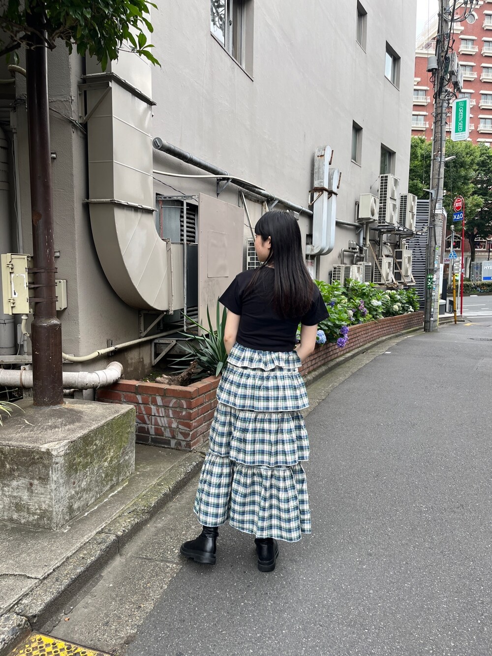 グリーン系のスカート、ブラック系のTシャツ/カットソー、ブラック系のブーツを着用したレディースの夏コーディネートの3枚目の写真