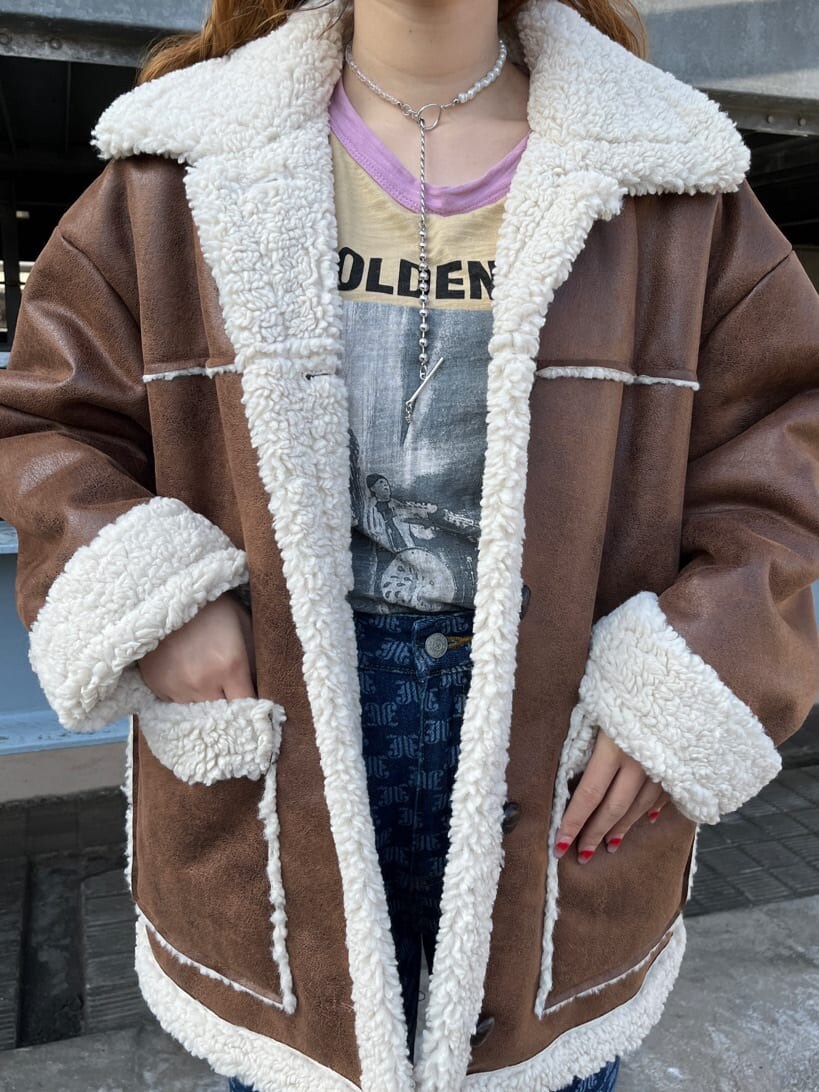 ブルー系のムートンコート、ブルー系のデニムパンツを着用したレディースの冬コーディネートの4枚目の写真