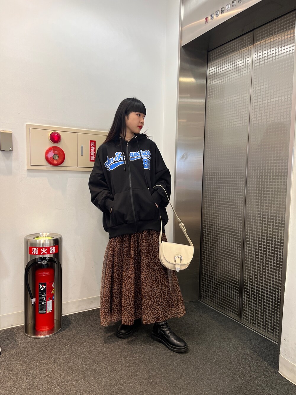 その他のスカート、ブラック系のパーカー、ホワイト系のショルダーバッグを着用したレディースの冬コーディネートの3枚目の写真