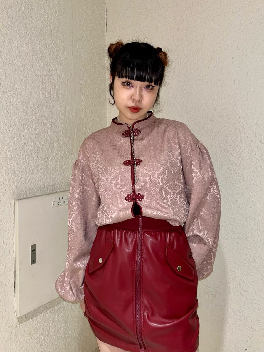 レッド系のスカート、ピンク系のシャツ/ブラウス、ホワイト系のブーツを着用したレディースの冬コーディネートの3枚目の写真