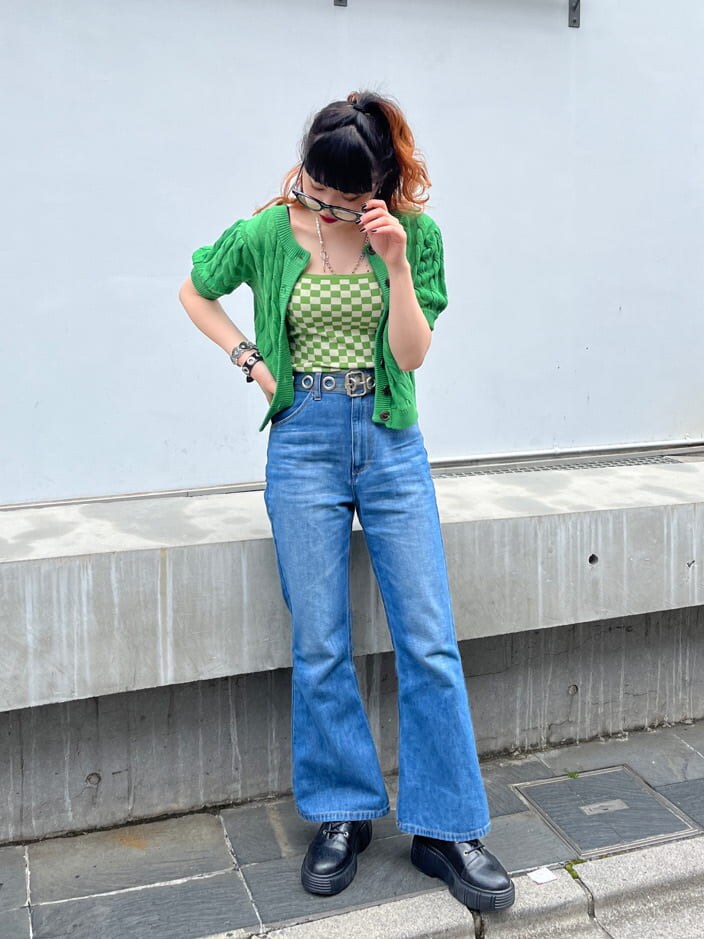 グリーン系のキャミソール、グリーン系のニット/セーター、ブラック系のサングラスを着用したレディースの春コーディネートの3枚目の写真