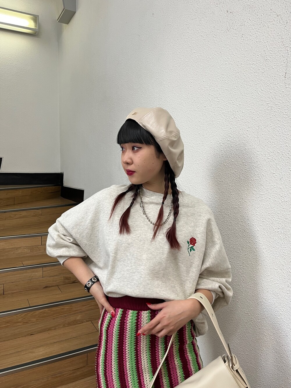 レッド系のスカート、グレー系のTシャツ/カットソー、ブラック系のブーツを着用したレディースの秋コーディネートの3枚目の写真