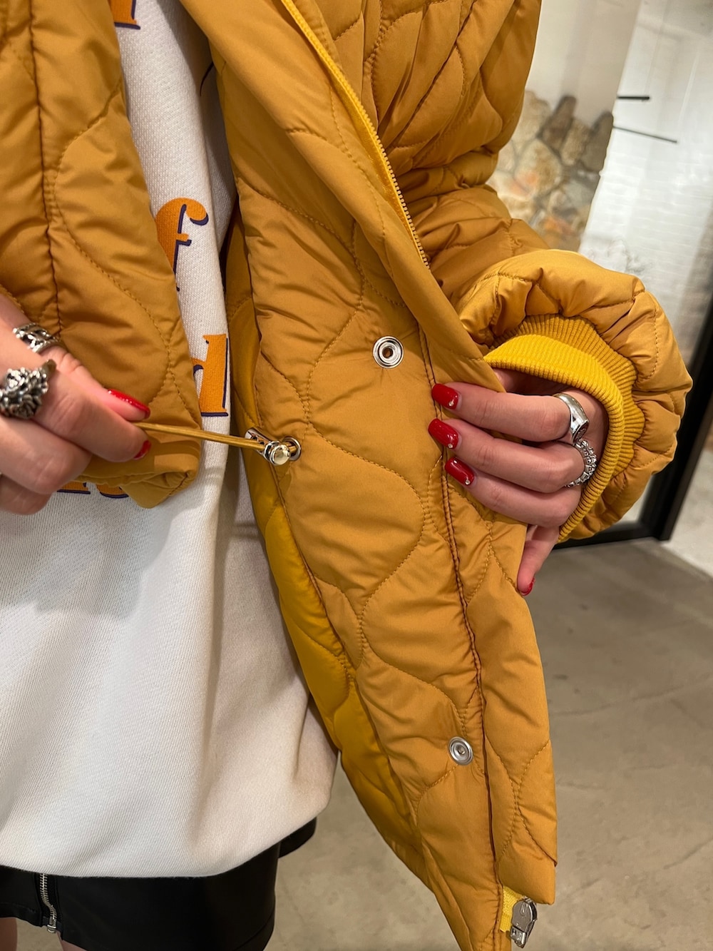 ブラック系のブーツ、グレー系のスウェット、イエロー系のその他アウターを着用したレディースの秋コーディネートの6枚目の写真