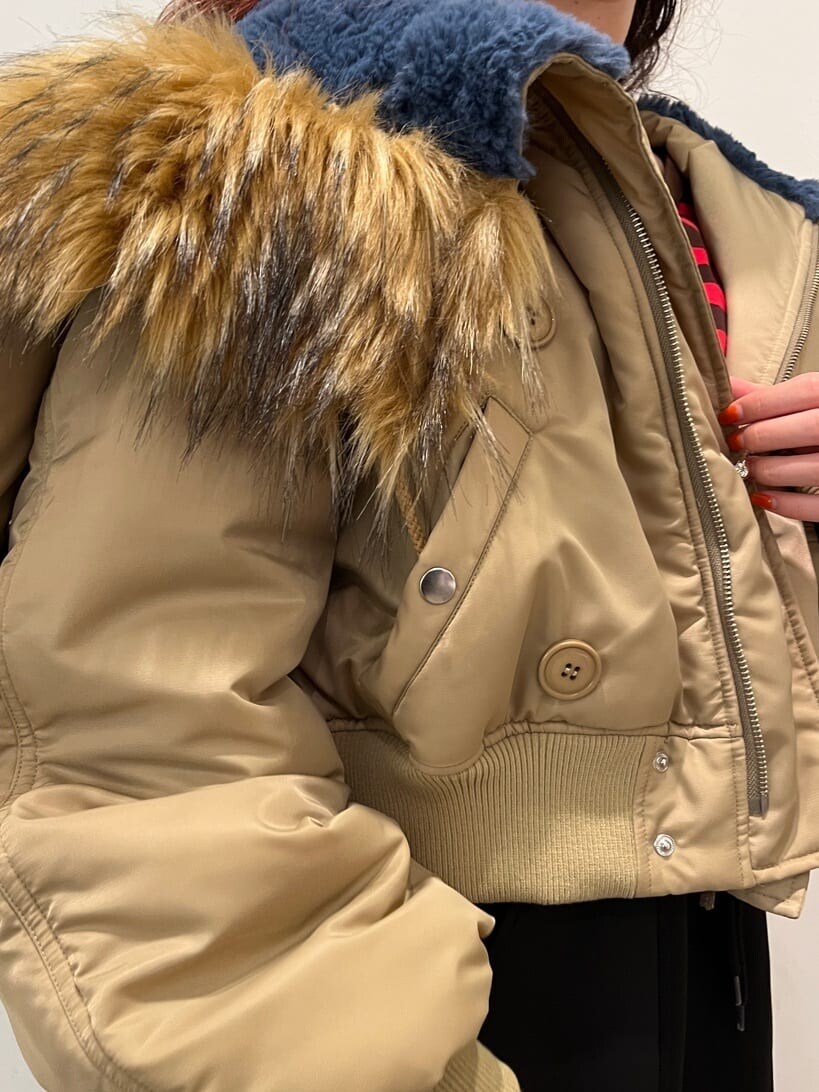 レッド系のTシャツ/カットソー、ベージュ系のその他アウター、ブラック系のスカートを着用したレディースの秋コーディネートの6枚目の写真