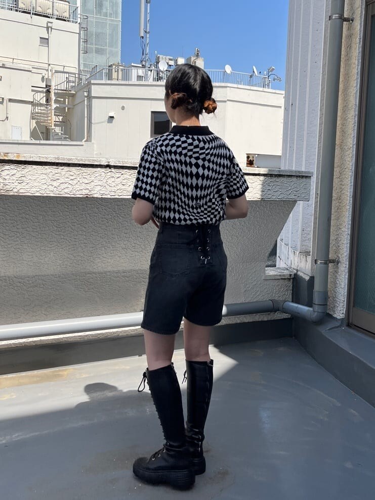 ブラック系のブーツ、ブラック系のニット/セーター、ブラック系のデニムパンツを着用したレディースの春コーディネートの3枚目の写真