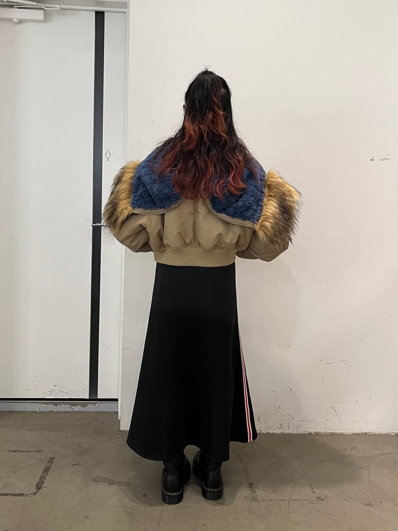 レッド系のTシャツ/カットソー、ベージュ系のその他アウター、ブラック系のスカートを着用したレディースの秋コーディネートの3枚目の写真