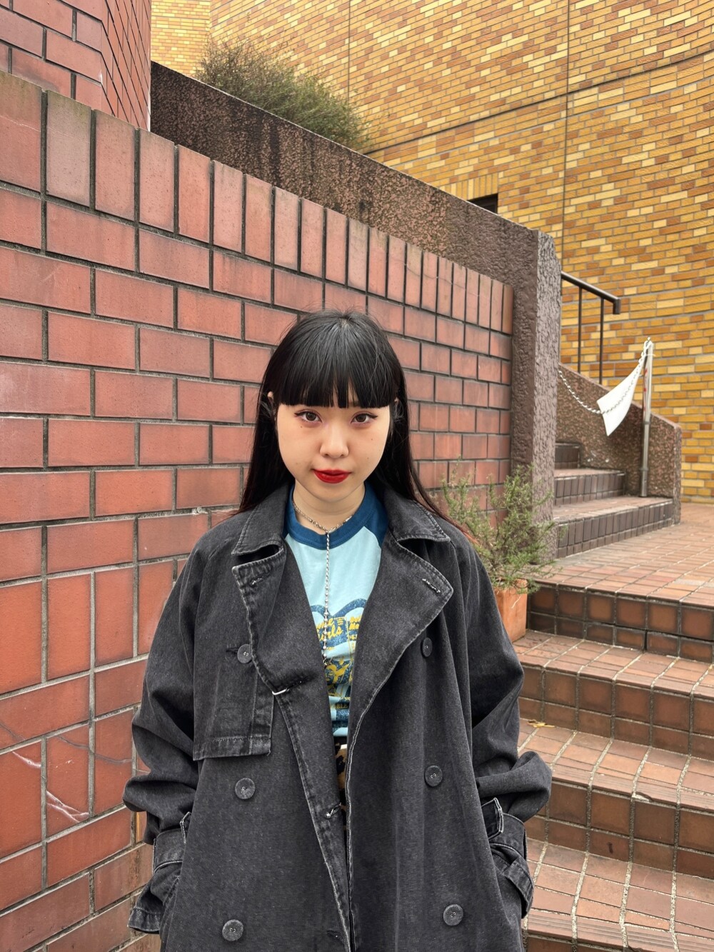 ブラック系のトレンチコート、ブラウン系のその他パンツ、ホワイト系のTシャツ/カットソーを着用したレディースの冬コーディネートの4枚目の写真