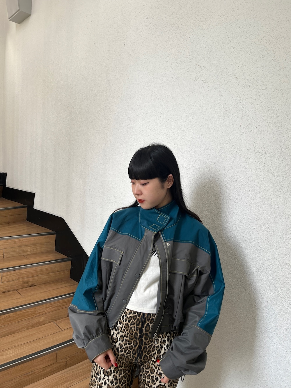 グリーン系のブルゾン、ブラウン系のその他パンツ、ホワイト系のタンクトップを着用したレディースの秋コーディネートの5枚目の写真