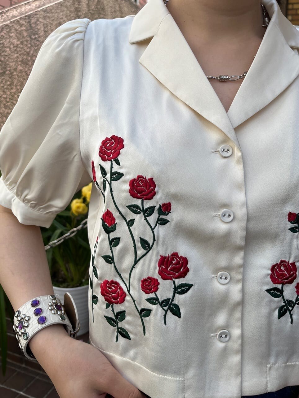 ホワイト系のボストンバッグ、ブラック系のブーツ、ブルー系のデニムスカートを着用したレディースの夏コーディネートの4枚目の写真