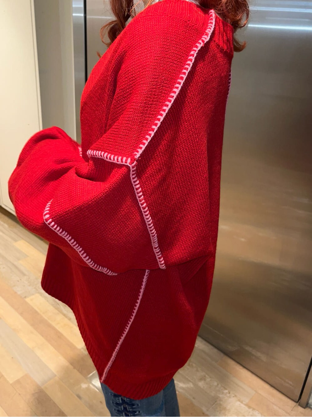 レッド系のニット/セーター、ホワイト系のTシャツ/カットソーを着用したレディースの冬コーディネートの4枚目の写真