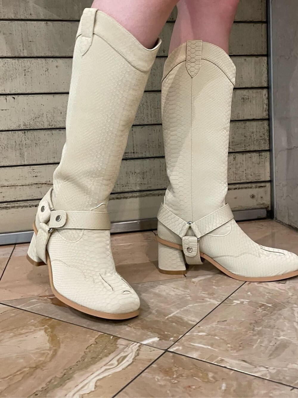 グリーン系のブーツ、ホワイト系のムートンコートを着用したレディースの夏コーディネートの6枚目の写真