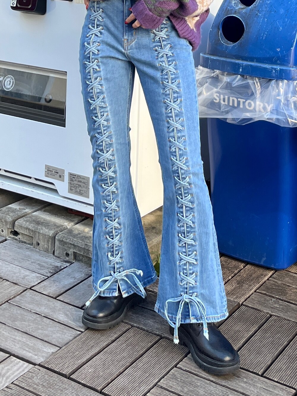 ブルー系のデニムパンツ、ブラック系のニット/セーター、ブラック系のブーツを着用したレディースの秋コーディネートの5枚目の写真