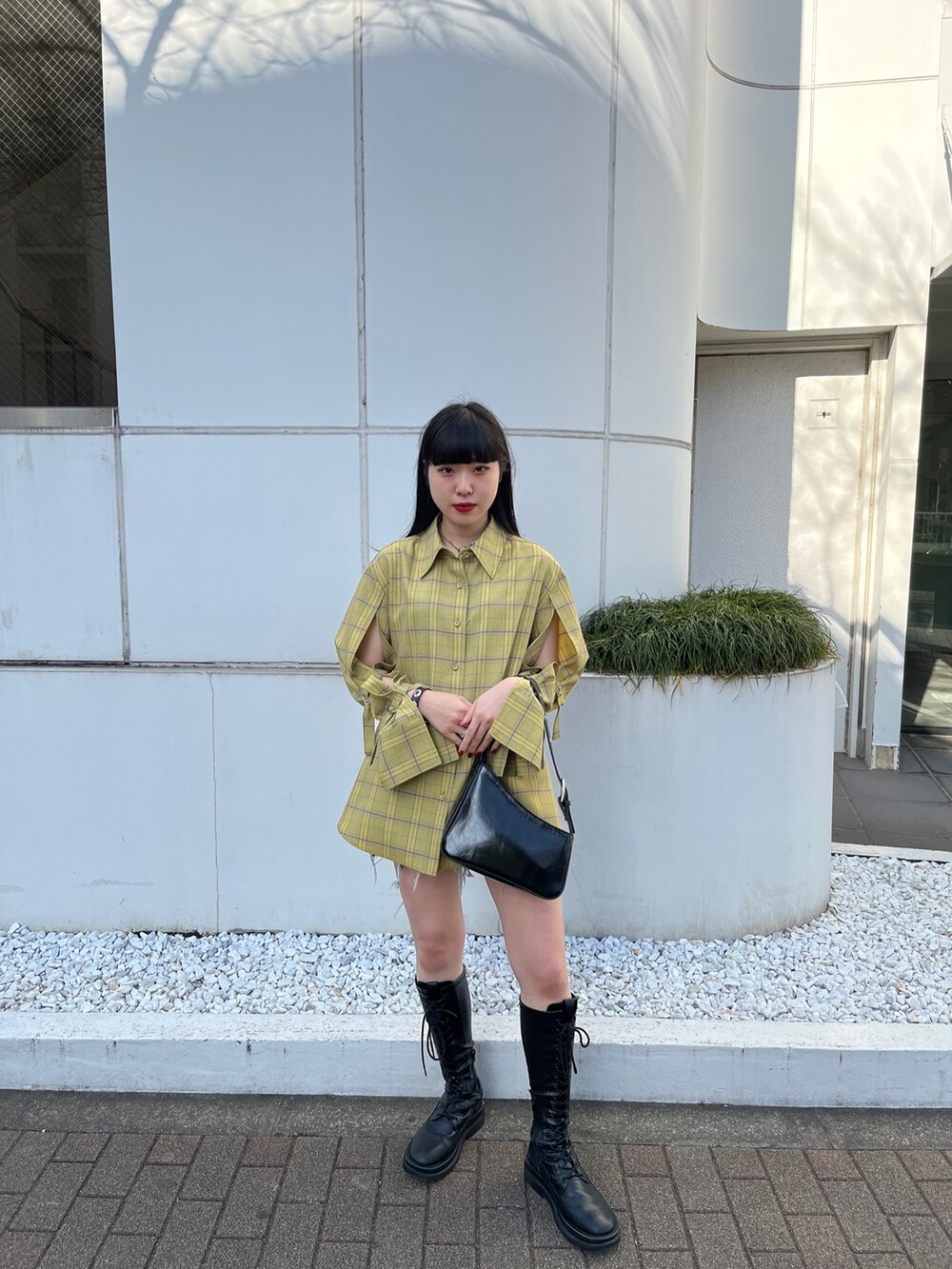 ブルー系のハンドバッグ、ブラック系のブーツ、その他のシャツ/ブラウスを着用したレディースの春コーディネートの2枚目の写真