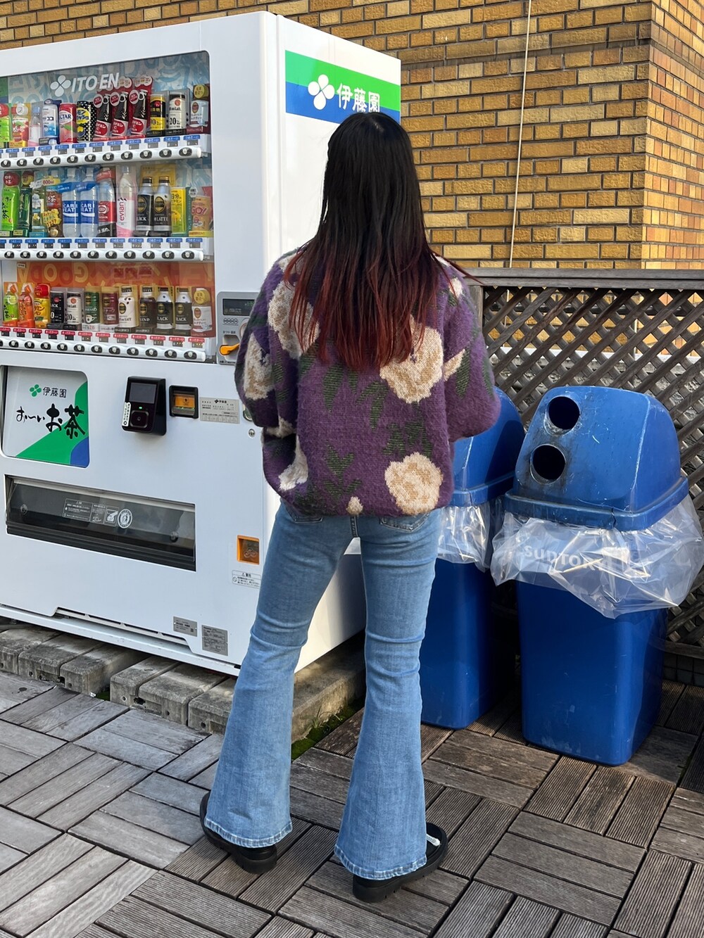 ブルー系のデニムパンツ、ブラック系のニット/セーター、ブラック系のブーツを着用したレディースの秋コーディネートの3枚目の写真