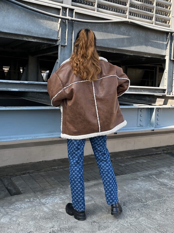 ブルー系のムートンコート、ブルー系のデニムパンツを着用したレディースの冬コーディネートの3枚目の写真