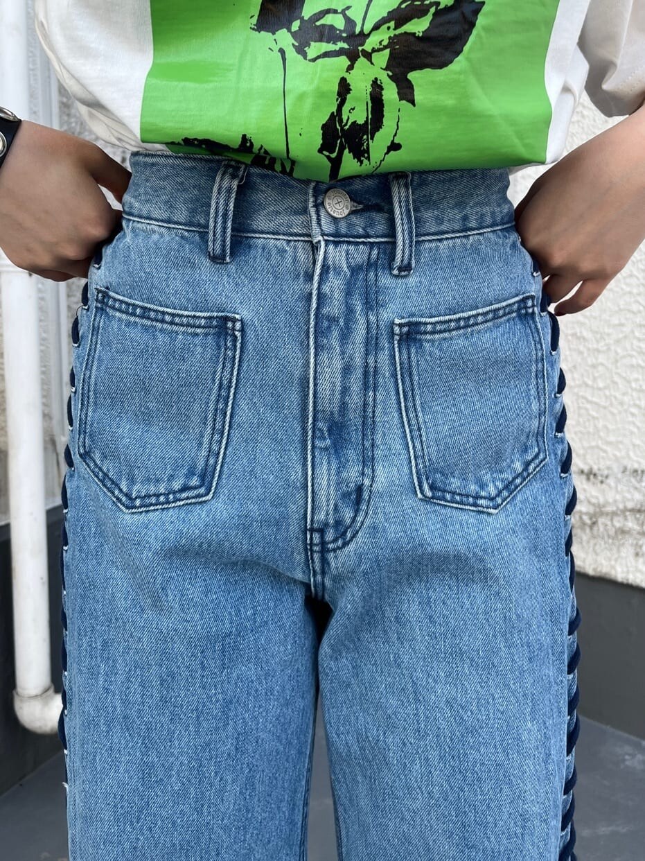 ブラック系のブーツ、ホワイト系のTシャツ/カットソー、ブルー系のデニムパンツを着用したレディースの春コーディネートの5枚目の写真