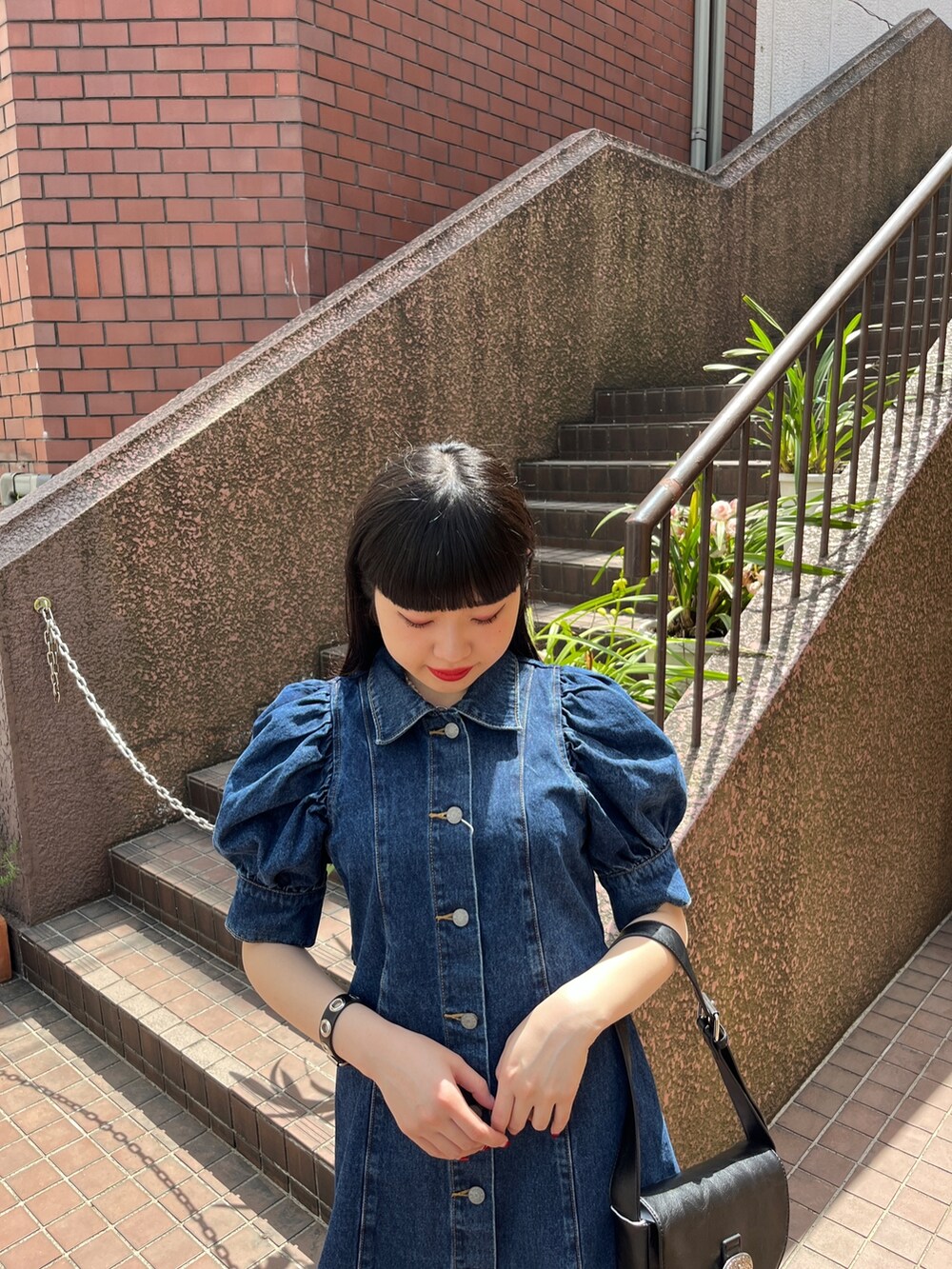 ホワイト系のショルダーバッグ、ブラック系のブーツ、ブルー系のワンピースを着用したレディースの春コーディネートの4枚目の写真