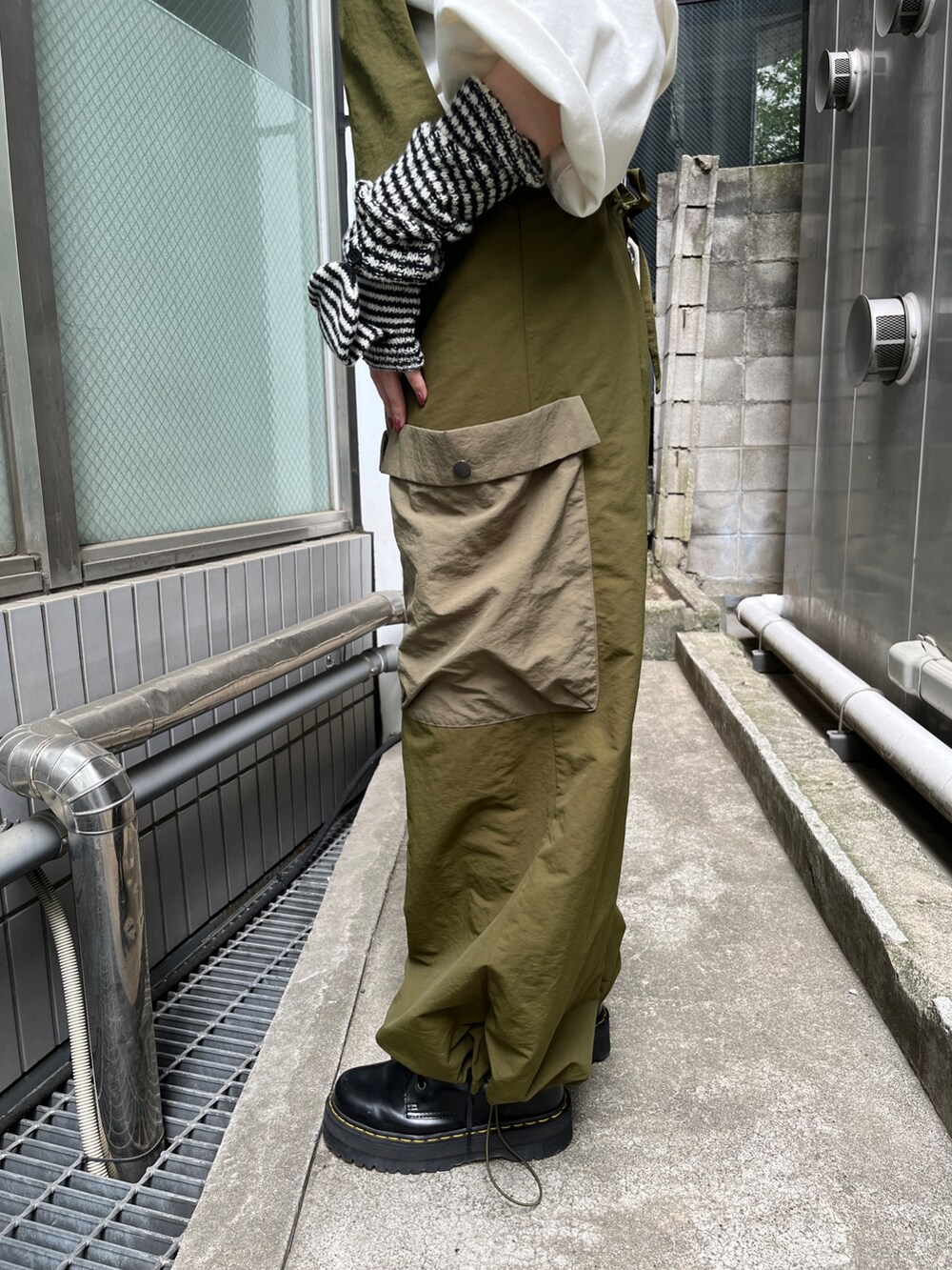 ホワイト系のTシャツ/カットソー、ブラック系のブーツ、ブラック系のアームカバーを着用したレディースの夏コーディネートの8枚目の写真